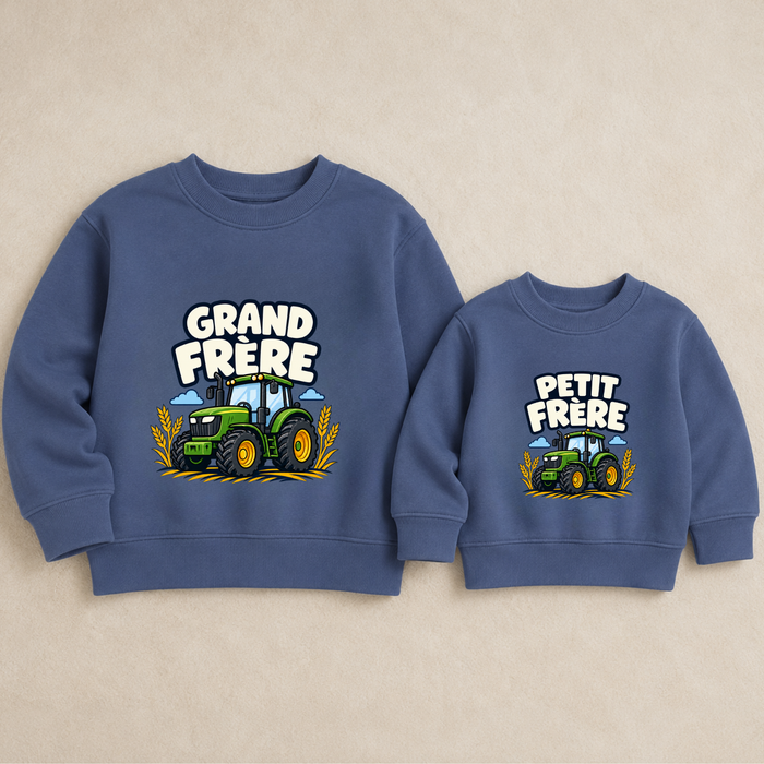 Sweaters bleus assortis grand frère et petit frère avec motif tracteur