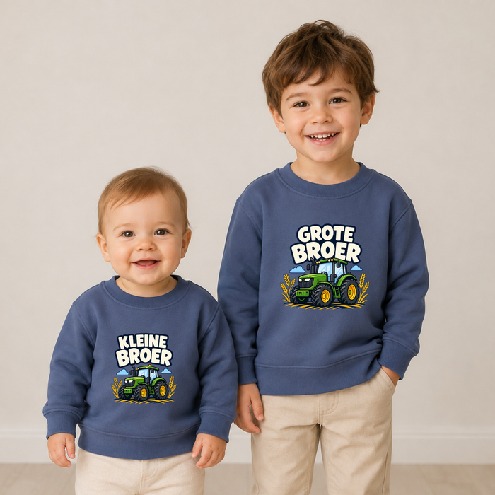 Grote broer en kleine broer in blauwe tractor sweaters